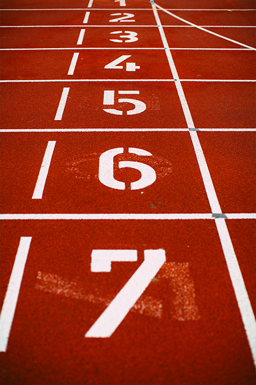 Athletes training on a running track at an athletics training camp